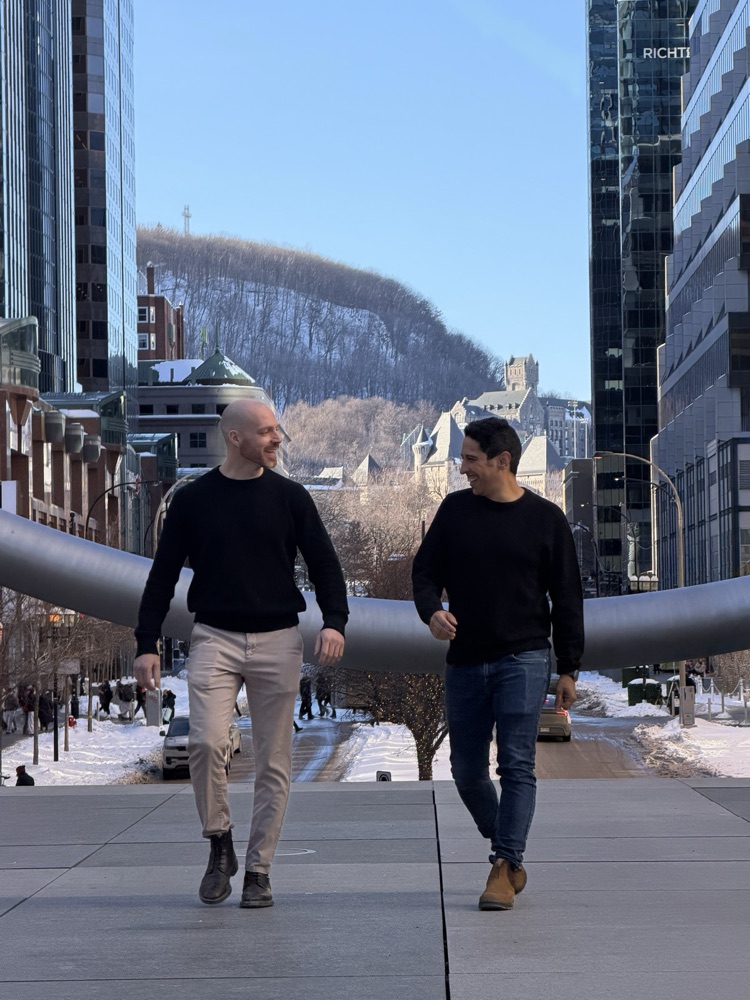 Mehdi Merai and Gabriel De Lisi walking together in downtown Montreal, with Mont Royal in the background